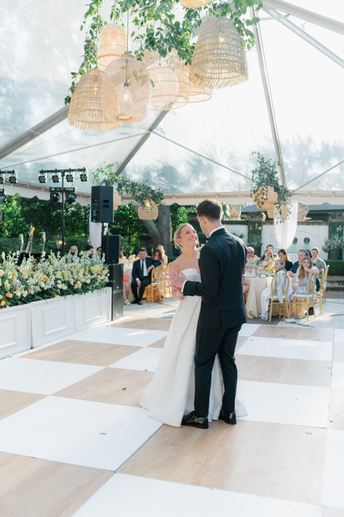 Bride and groom first dance under the tent at outdoor wedding reception in Charleston. 