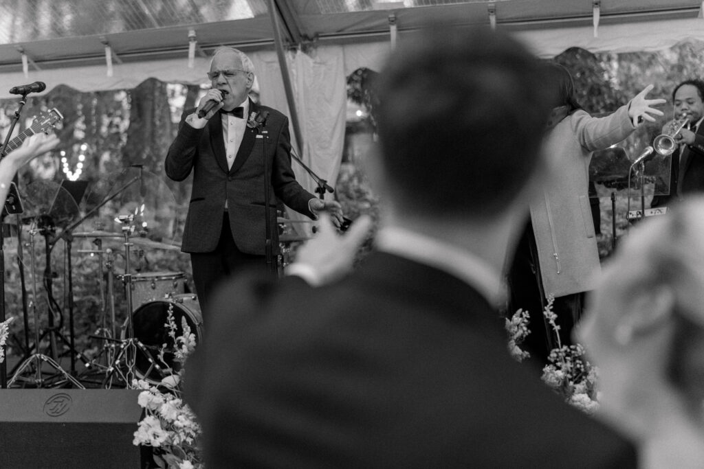 Father of the groom performing with band at Thomas Bennett House wedding. 