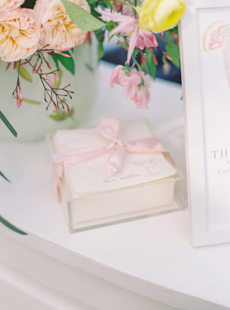 Intentional wedding details. Pink bow tied around custom cocktail napkins. Pink and yellow Charleston spring wedding.