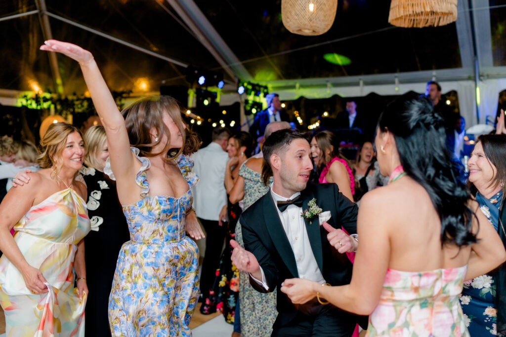 Groom on the dance floor with wedding guests. 