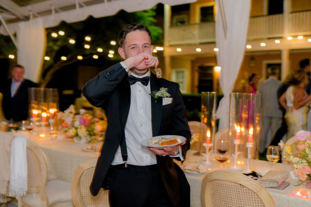 Groom tries to eat some wedding cake on the dance floor. 