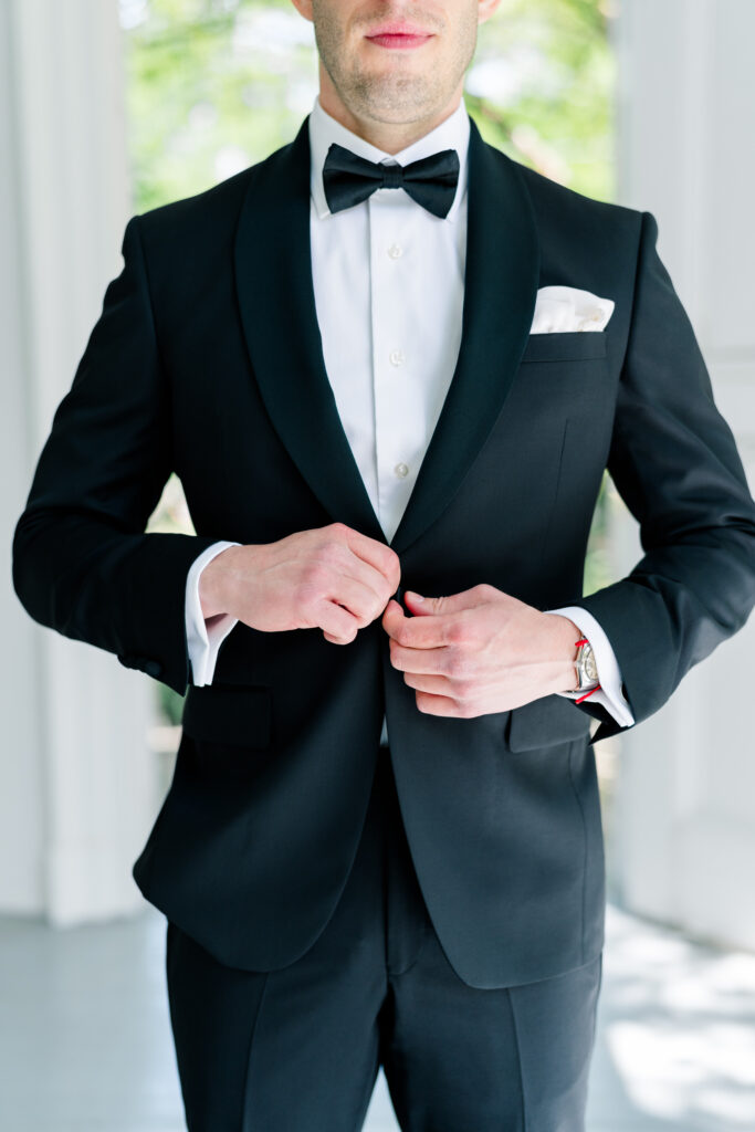 Groom buttons tuxedo jacket.