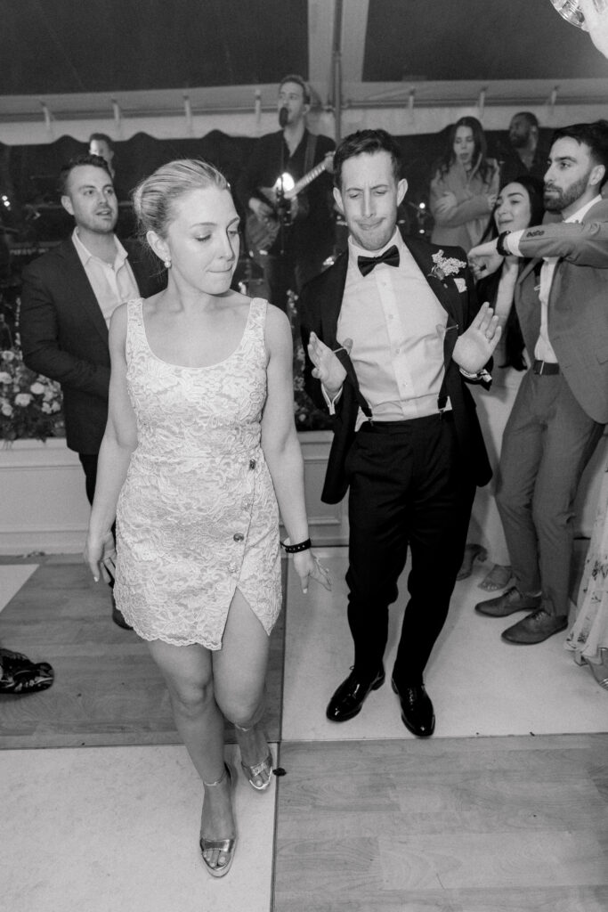 Bride and groom let loose on the dance floor. Outdoor wedding reception in downtown Charleston. 