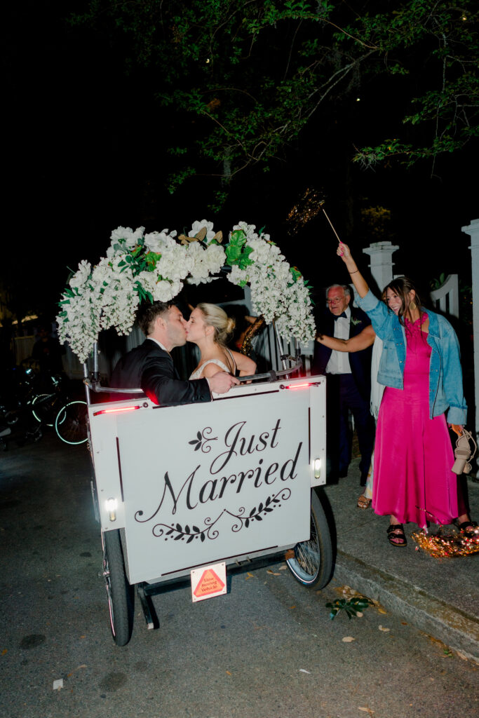 Bride and groom kiss in the back of rickshaw. Charleston getaway car. 