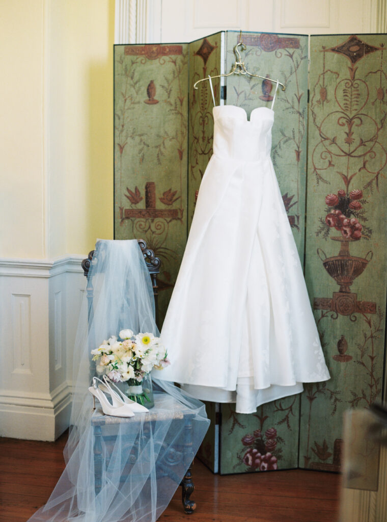 Charleston film photographer. Wedding dress hanging with heels and flowers. 