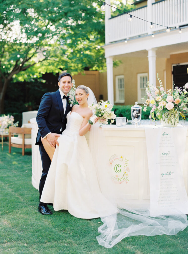 Film photographer in Charleston, SC. Bride and groom in front of bar with custom logo. 