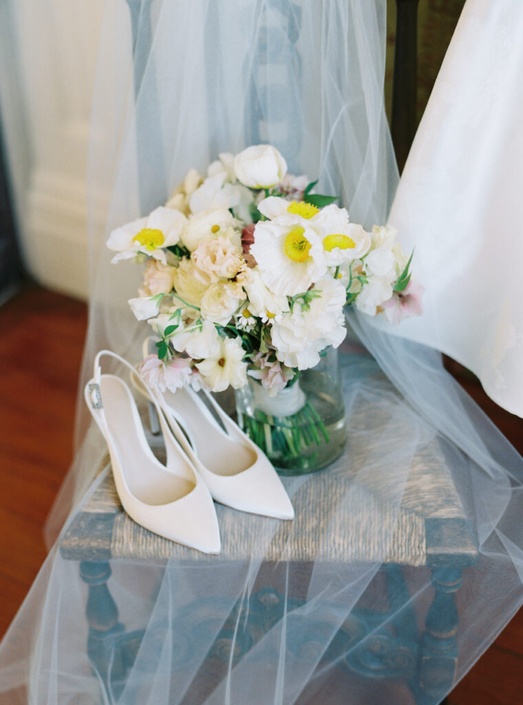 Brides flowers on a chair with veil and wedding heels. 