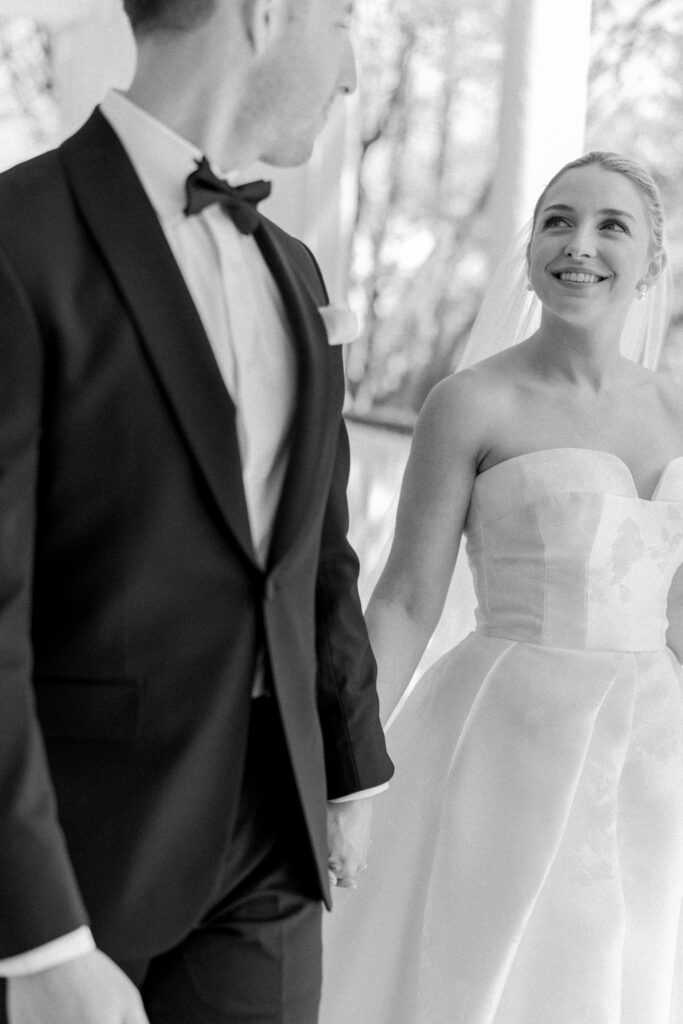 Black and white photo of bride looking at groom. 