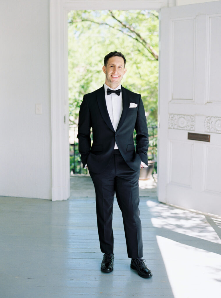 Film portrait of groom in black tuxedo. 