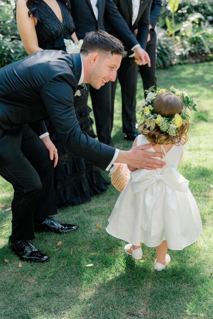 Groom and flower girl at the top of the aisle. 