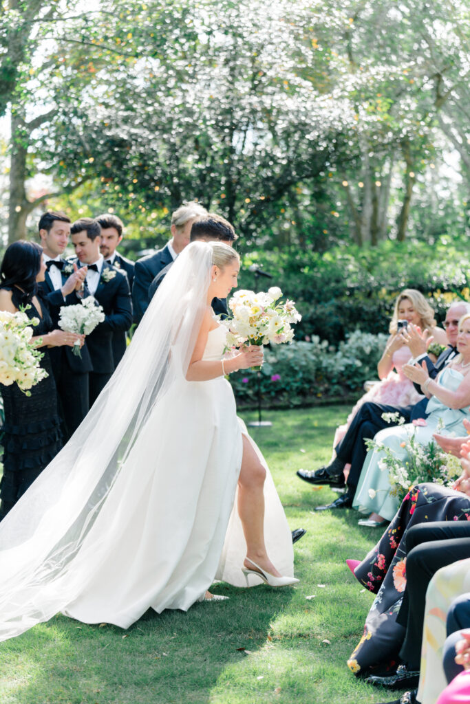 Bride and groom walk down the aisle as husband and wife. Bride's slit in the front of her dress with heel popping out. 