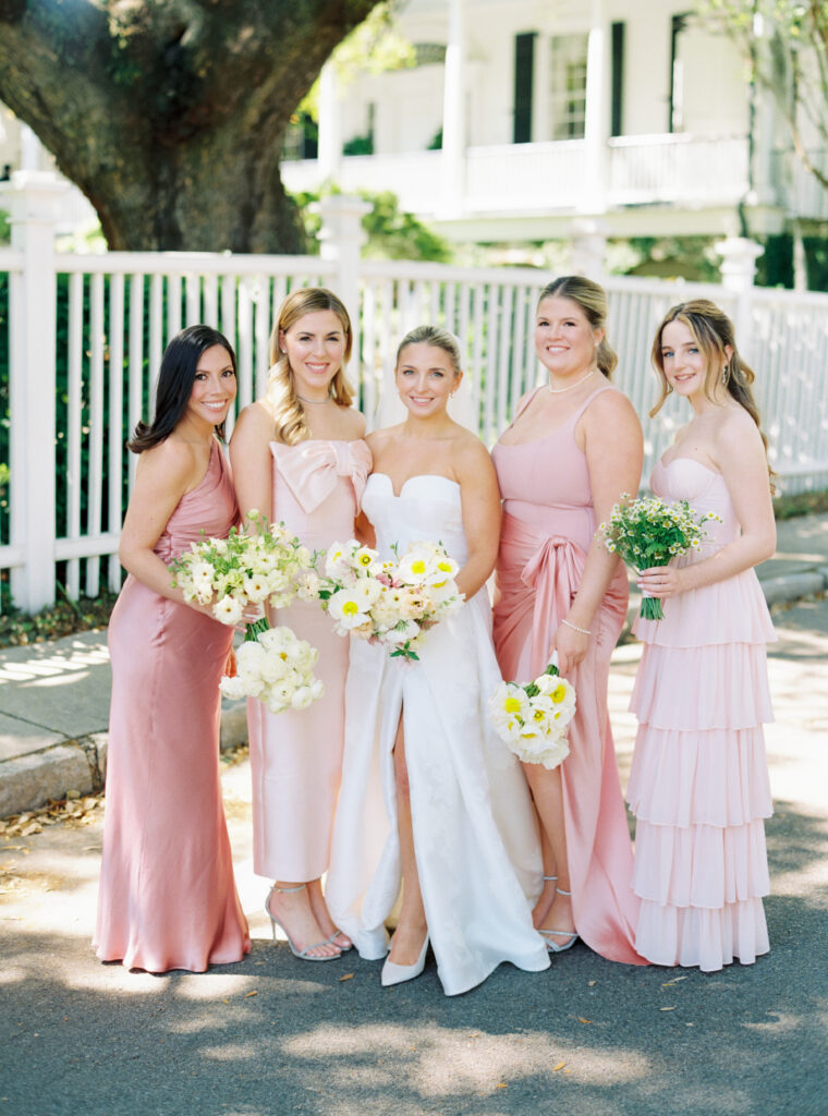 Bride and bridesmaids. Bridesmaids in varied tones of pink and mix-matched flowers. 