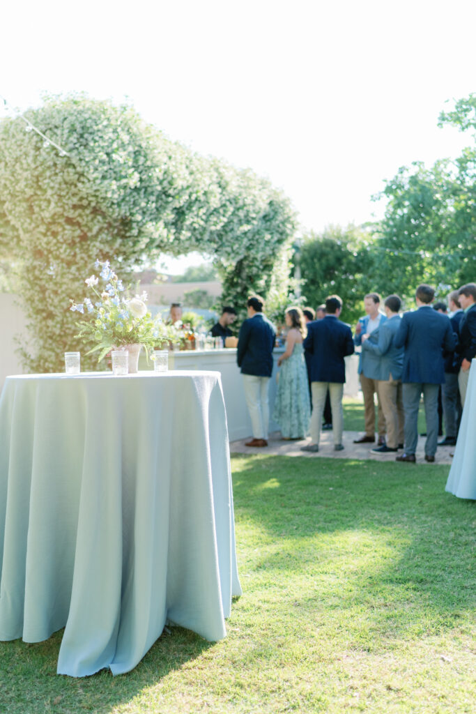 Guests arrive and head to the bar at outdoor spring destination rehearsal dinner in Beaufort South Carolina. 