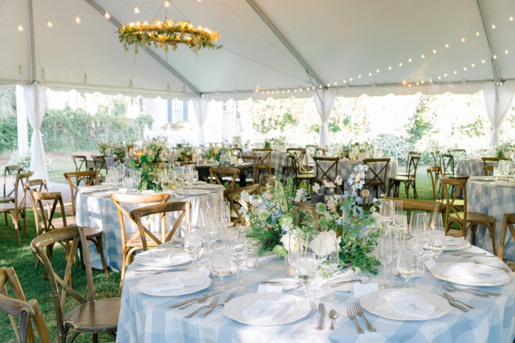 Blue and white rehearsal dinner under a tent with string lights. 