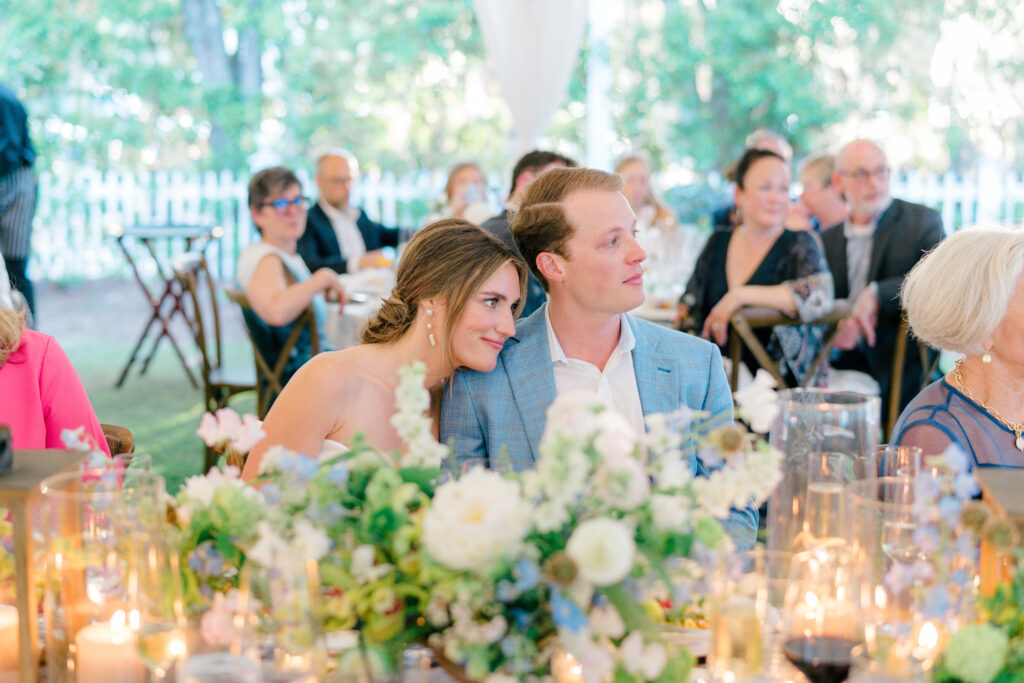 Bride and groom get close and listen to speeches at gorgeous outdoor rehearsal dinner in Beaufort SC.