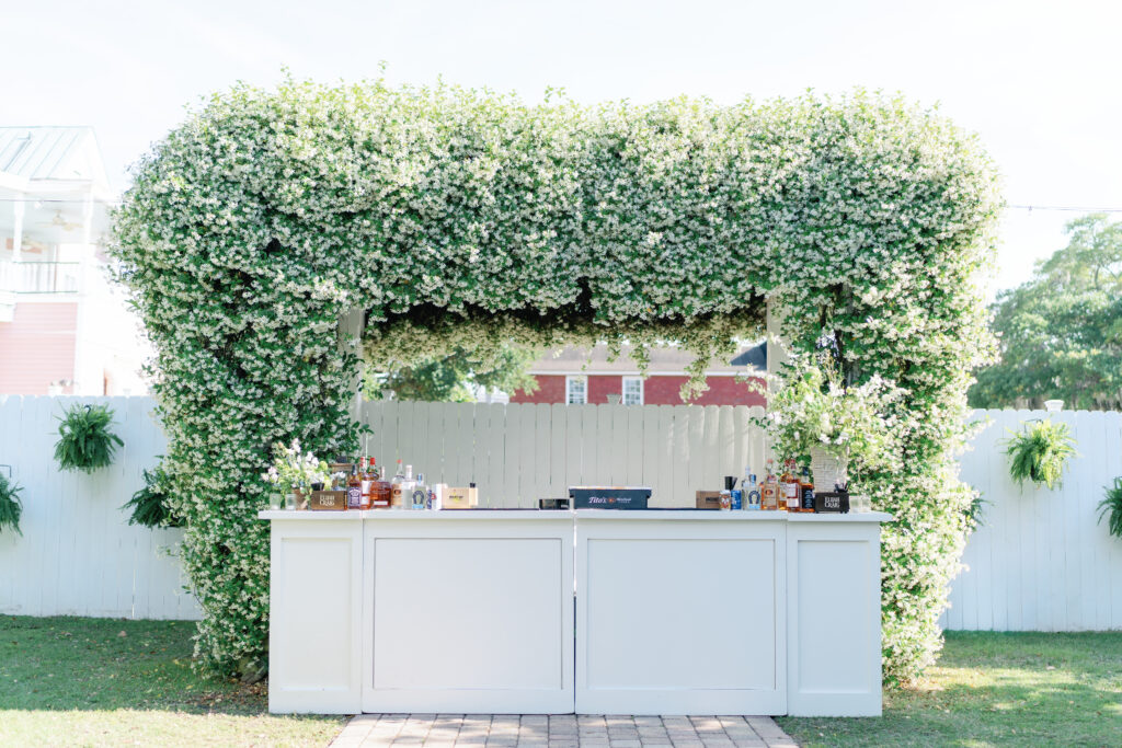 Wedding bar with big jasmine bloom at Beaufort Inn outdoor spring rehearsal dinner. 