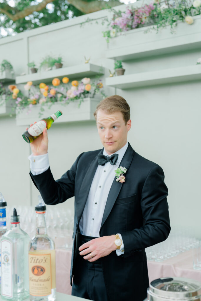 Groom gets behind the bar to grab a beer. 