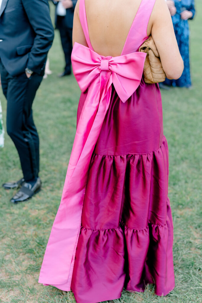 Wedding guest style. Deep pink dress with bold statement bow on the back. 