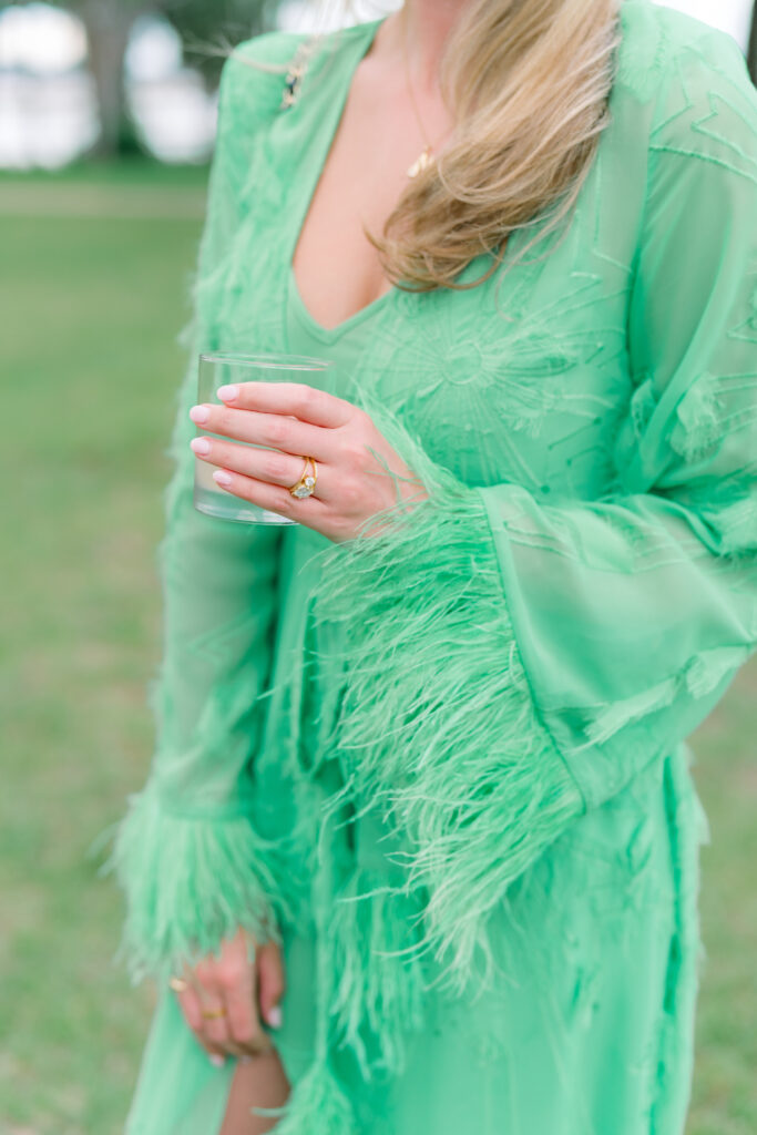 Cocktail hour wedding guest style. Green long sleeved dress with fringe collar. 