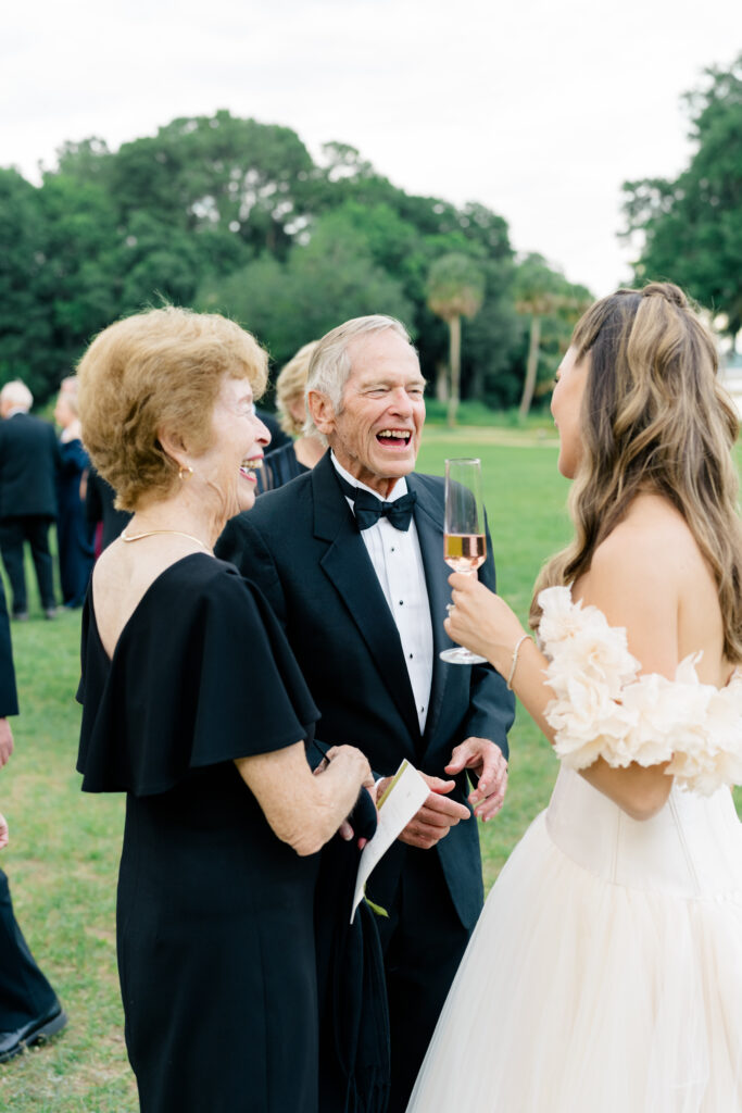 Bride laughs with guests at cocktail hour. 