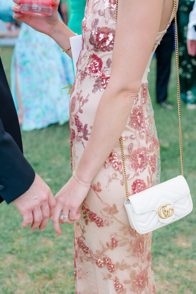 Wedding guests holding hands at cocktail hour. 