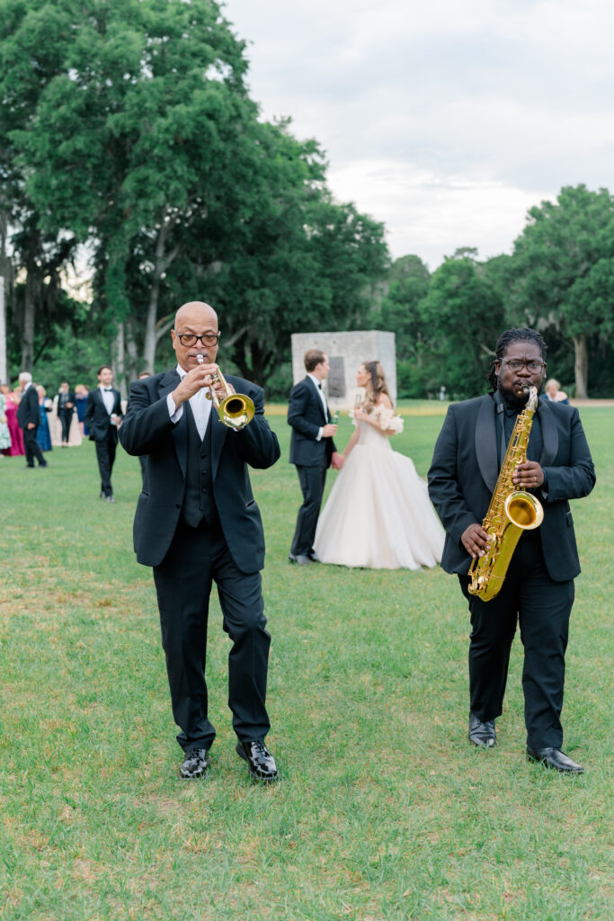 Horns lead wedding guests from cocktail hour to wedding reception tent. 