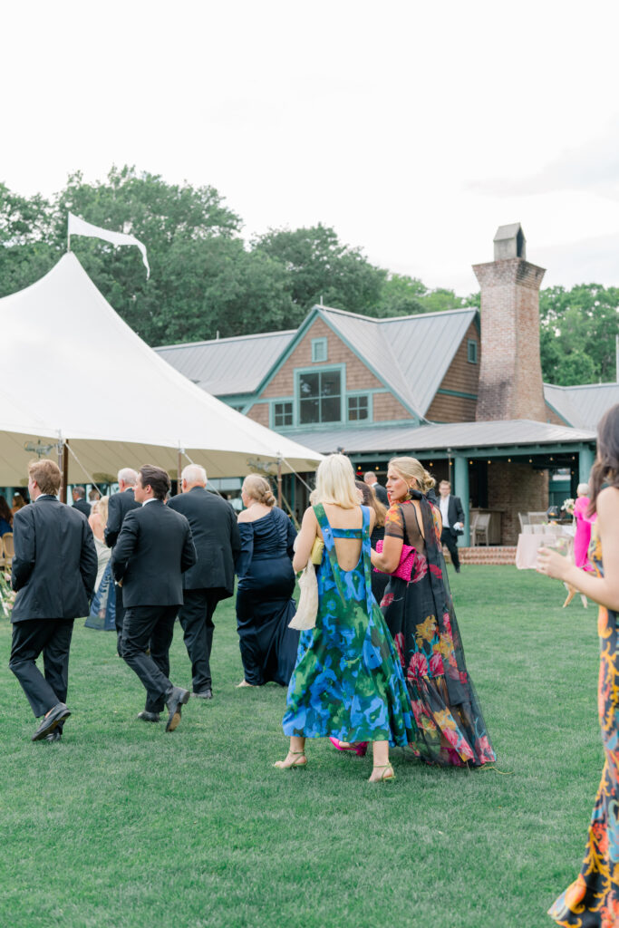 Wedding guests head to outdoor reception tent at Old Tabby Links. 