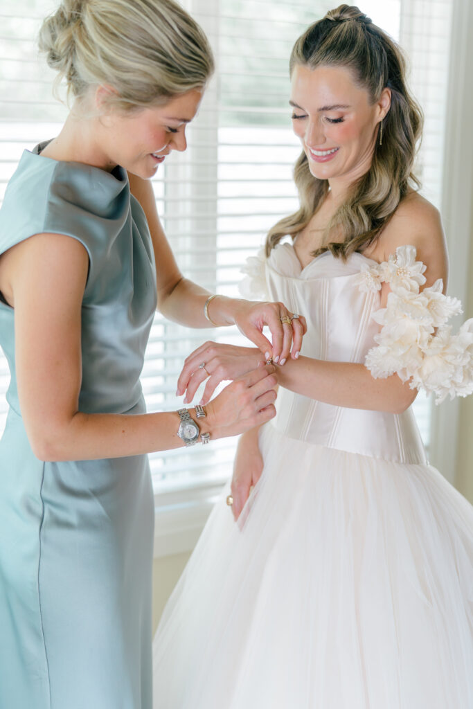 Maid of honor puts on brides bracelet. 