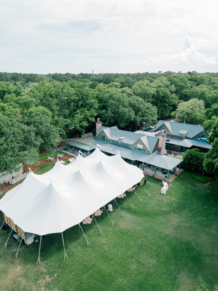 Drone photo of Old Tabby Links with sailcloth tent and lush green trees. 