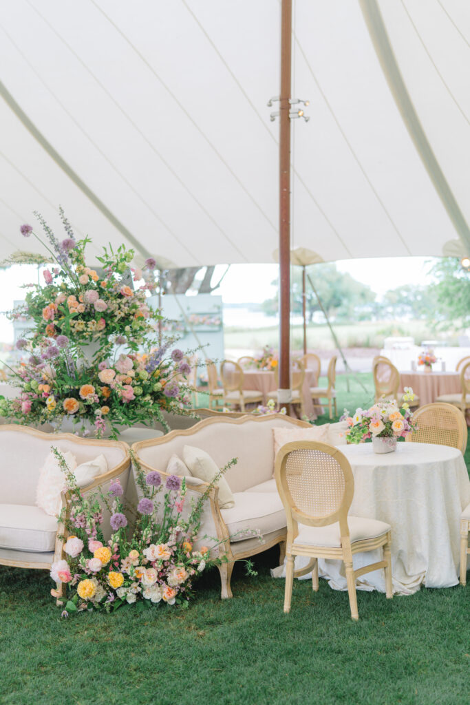 Wedding reception tent design with furniture and cocktail tables. Spring floral design from florist bride. 