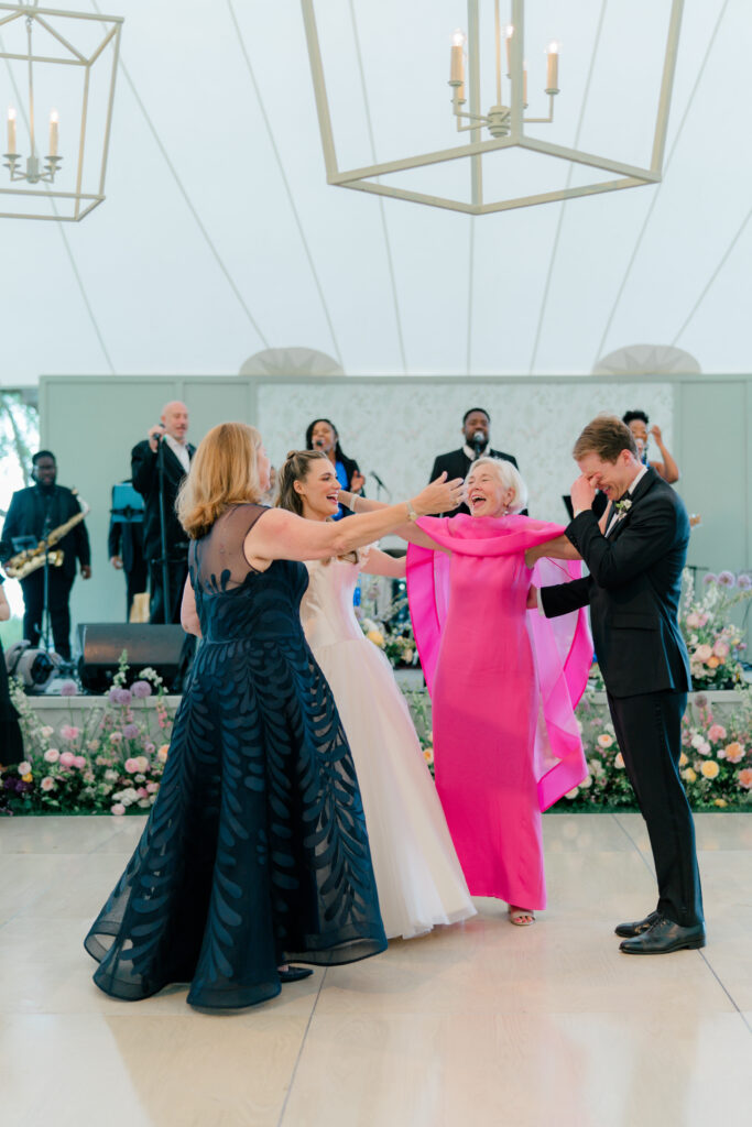 Bride and groom dance with their moms. Groom gets emotional on dance floor. 