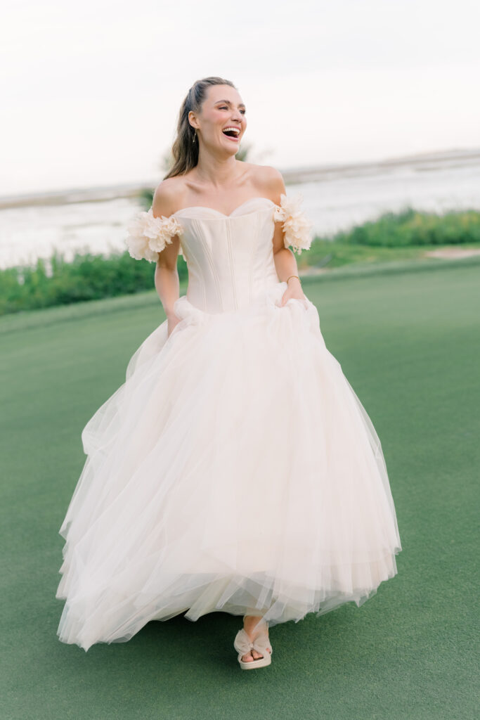 Crooked horizon. Bride laughing in blush pink wedding dress. Strapless with statement flower sleeves. 