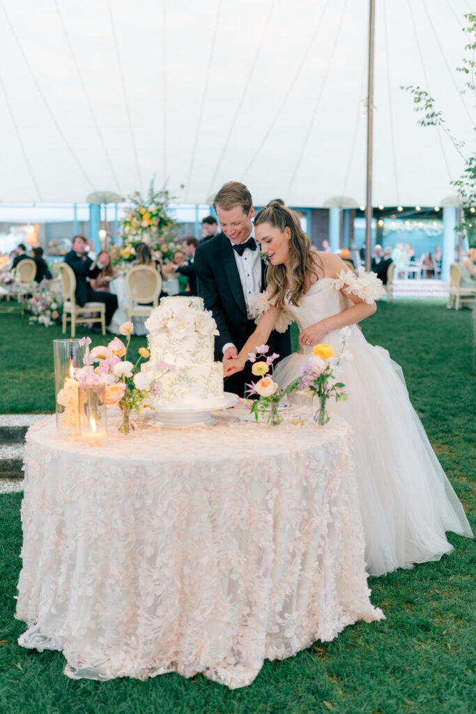 Bride and groom cut the cake at dusk. 