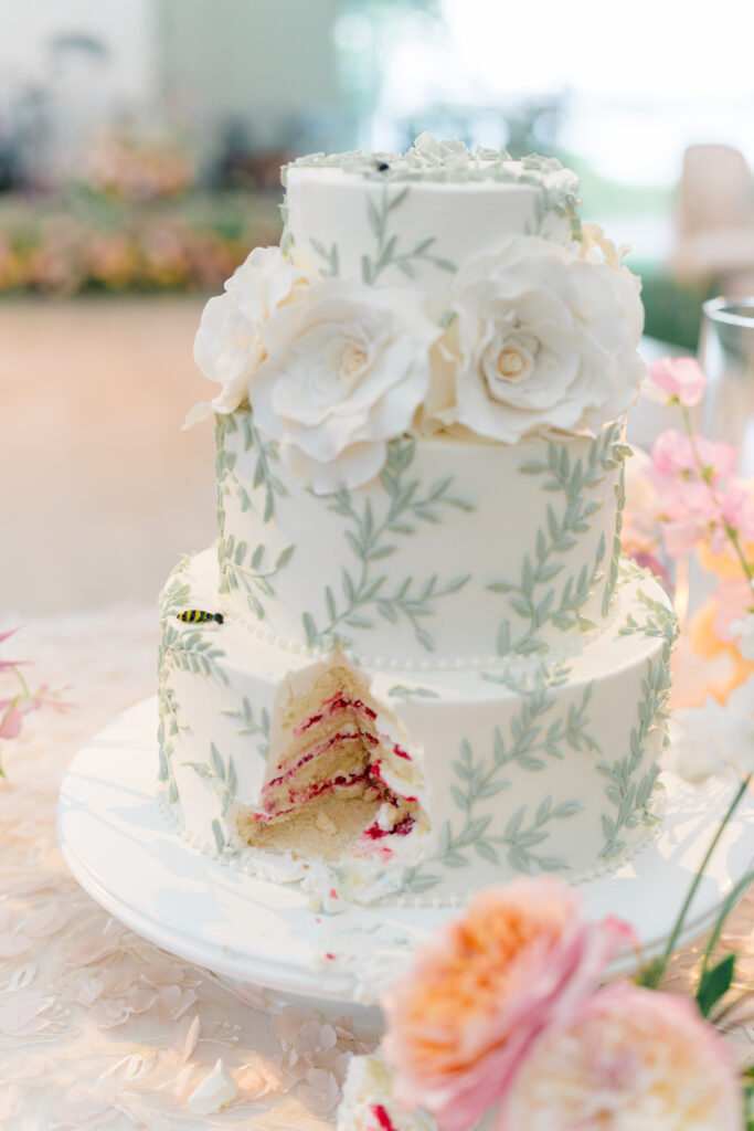 White and green cake with strawberry filling. Flower and vine design with hidden bees. 