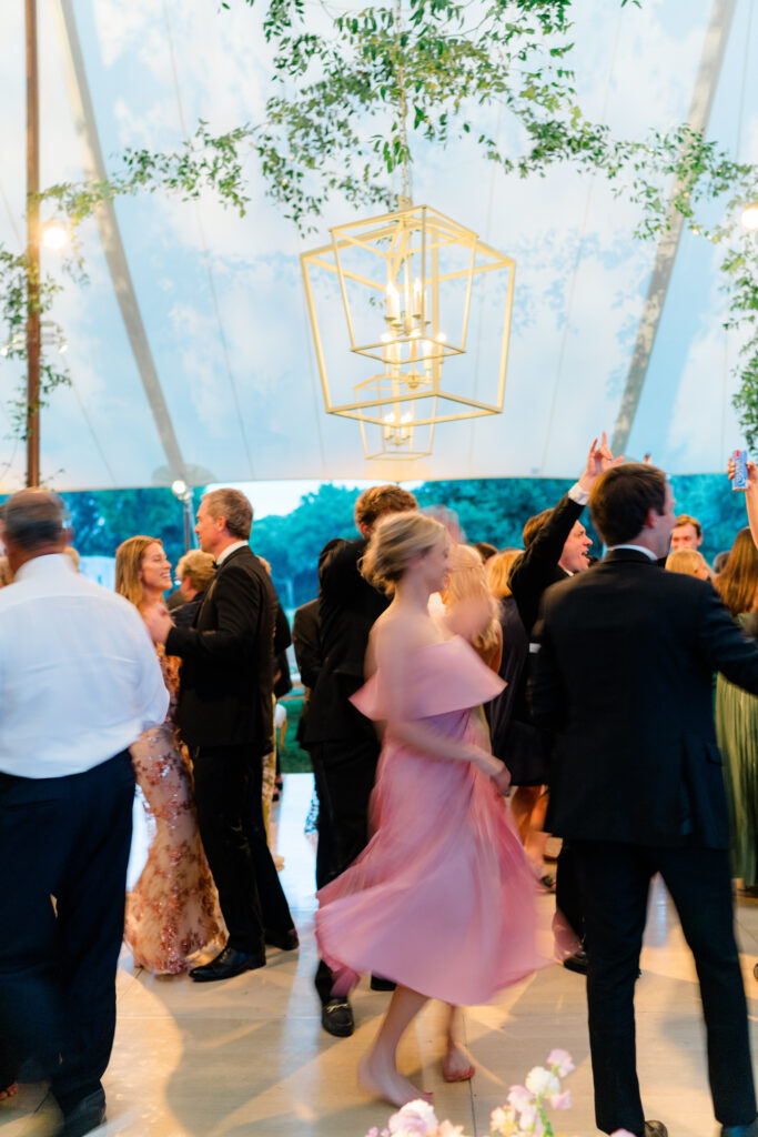 Motion blur photo of girl in pink dress spinning on the dance floor with lanterns. 