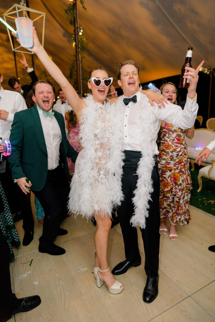 Bride and groom on the dance floor with wedding guest yelling. 