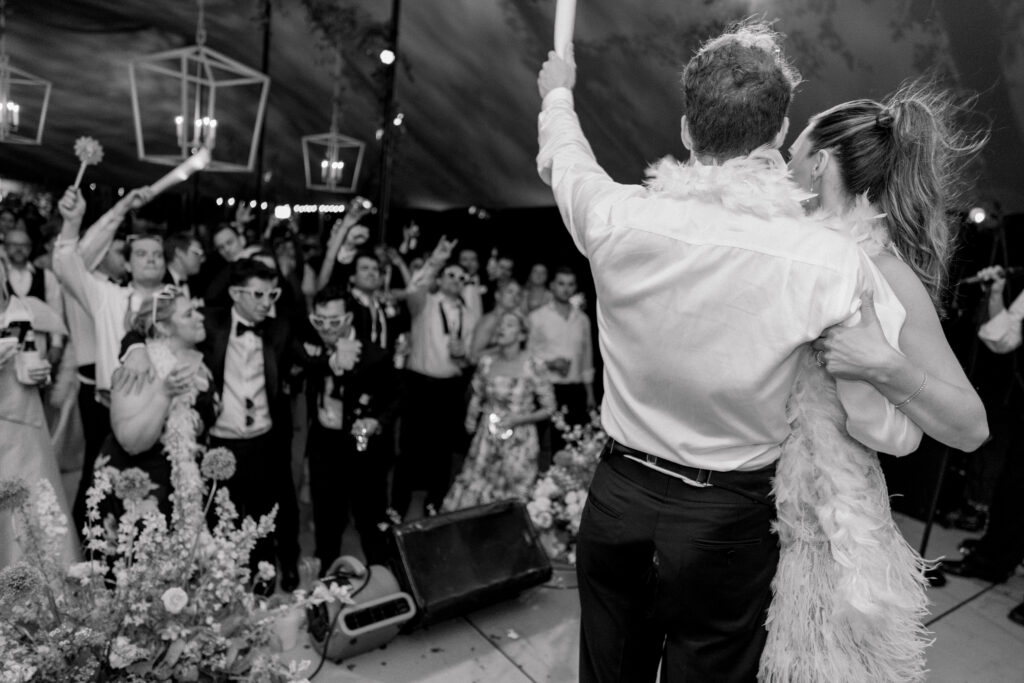 Bride and groom on stage leading the crowd. Black and white wedding photo.