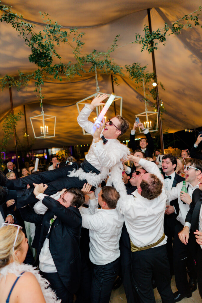 Groom crowdsurfing at the end of the night. 