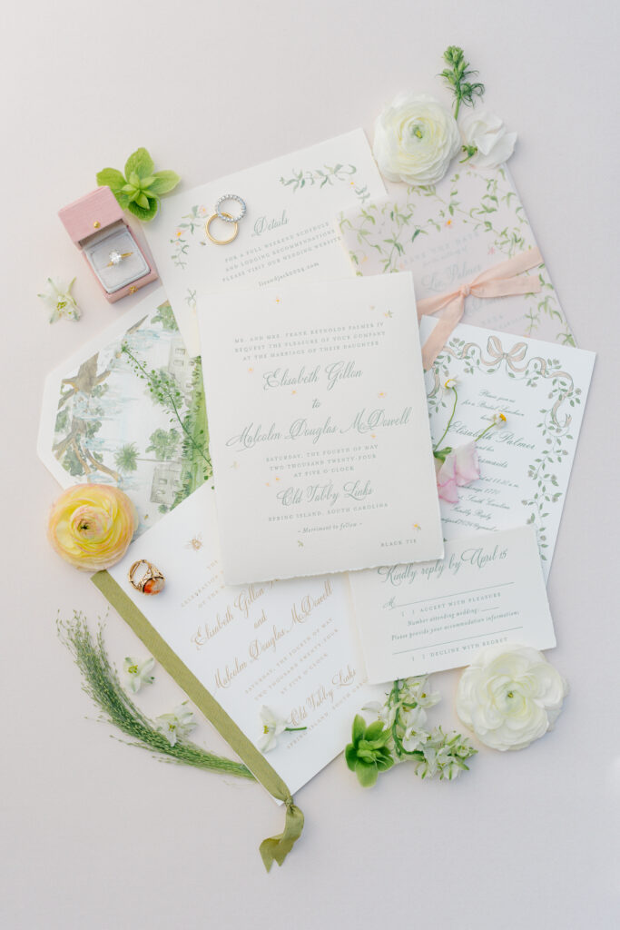 Green and white wedding invitations with touches of pink.