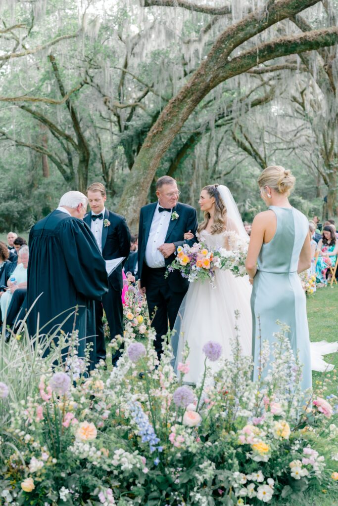 Bride looks at her dad at Spring Island wedding ceremony. Gorgeous spring flowers. 