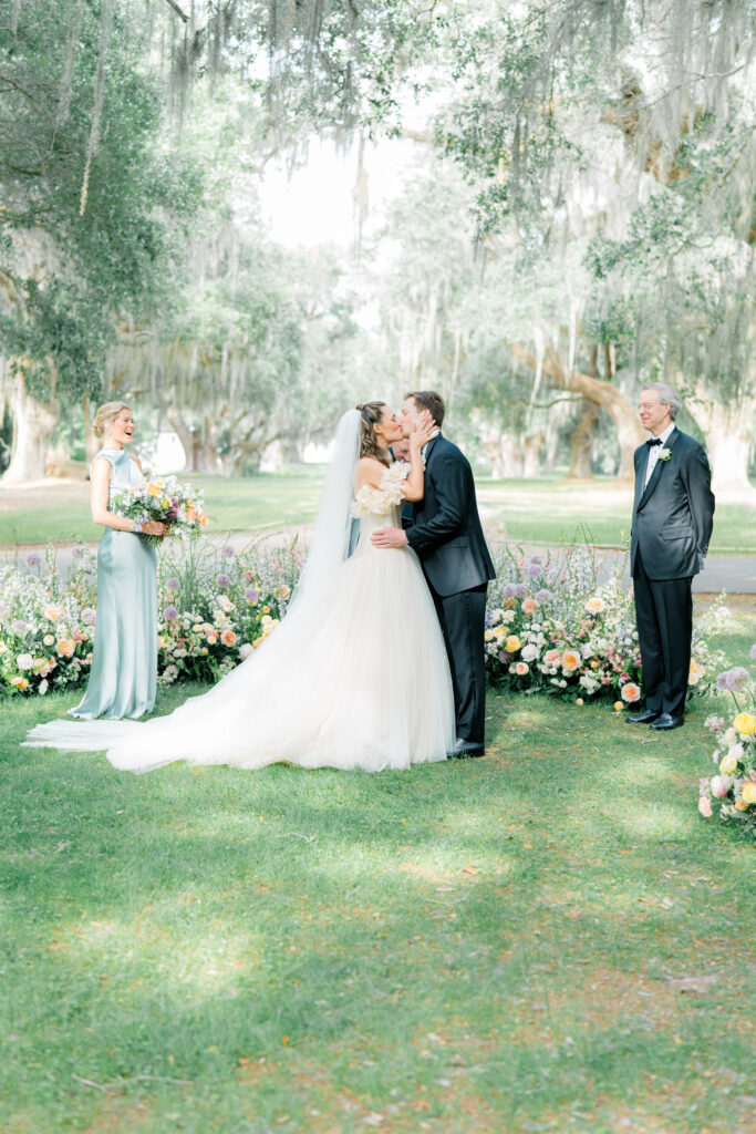 First kiss at outdoor wedding ceremony on Spring Island. 