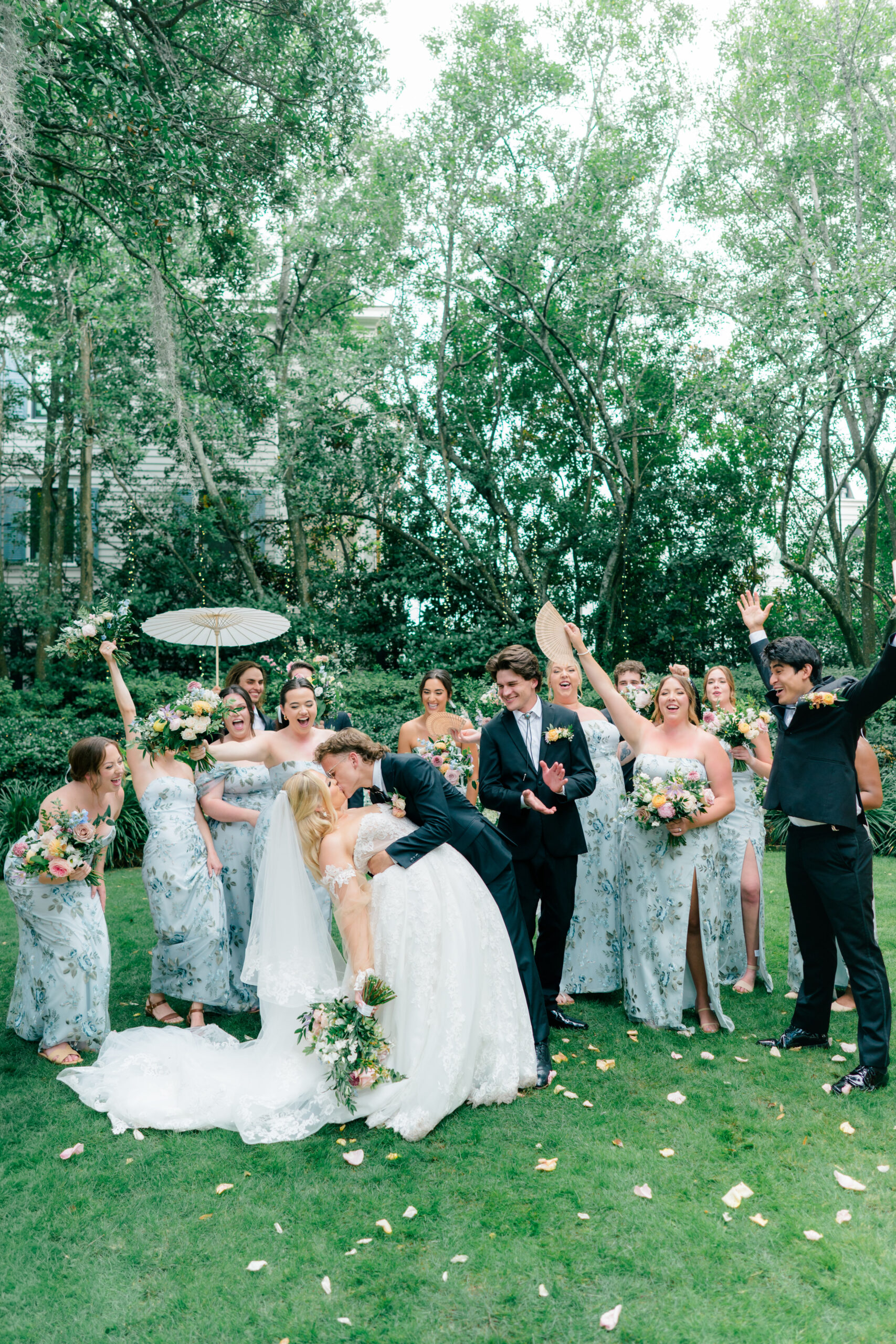 Full bridal party celebrating with bride and groom dip kiss. 