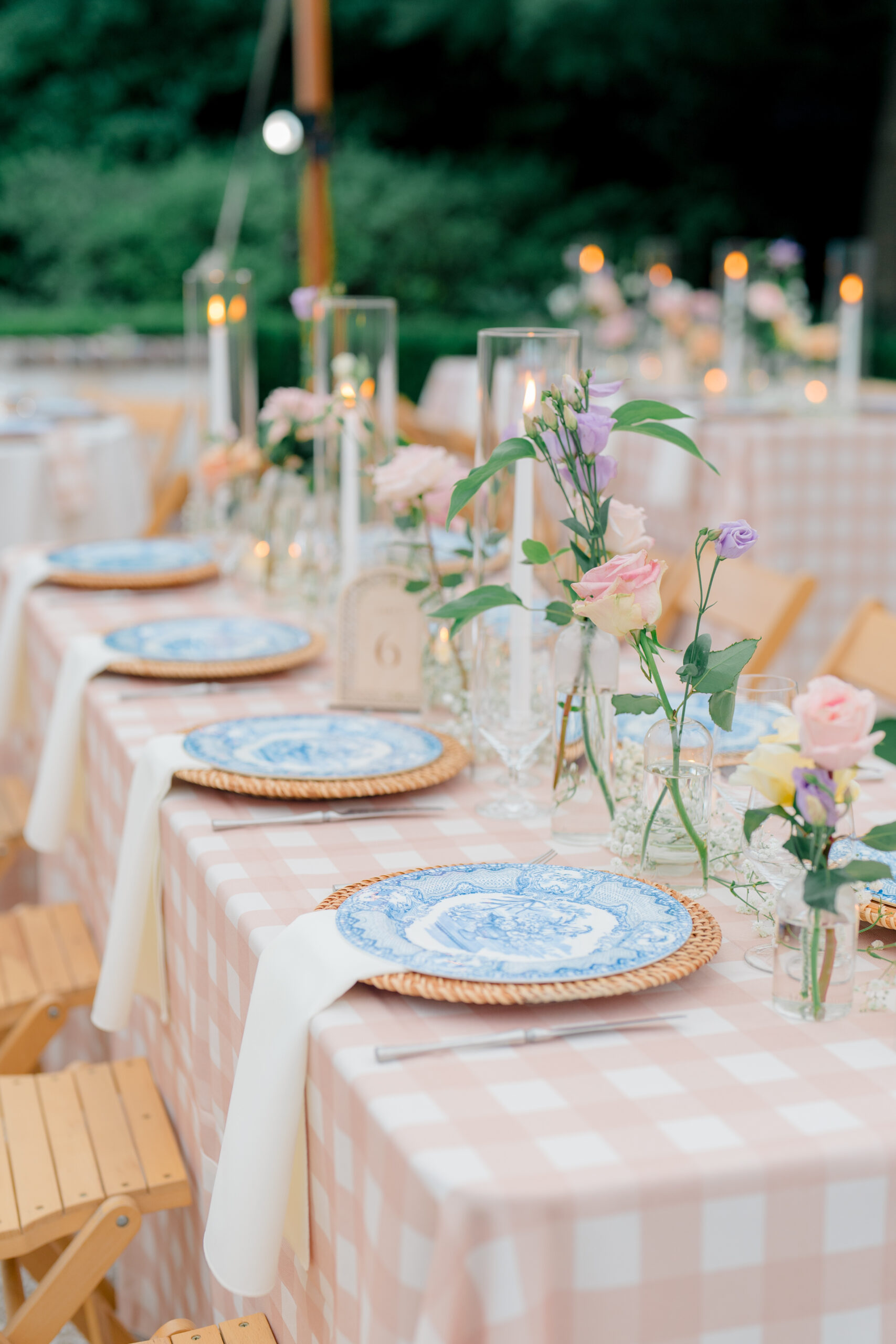 Mega-gingham table cloth, blue china plates, and wicker charger. Delicate small table top florals. 