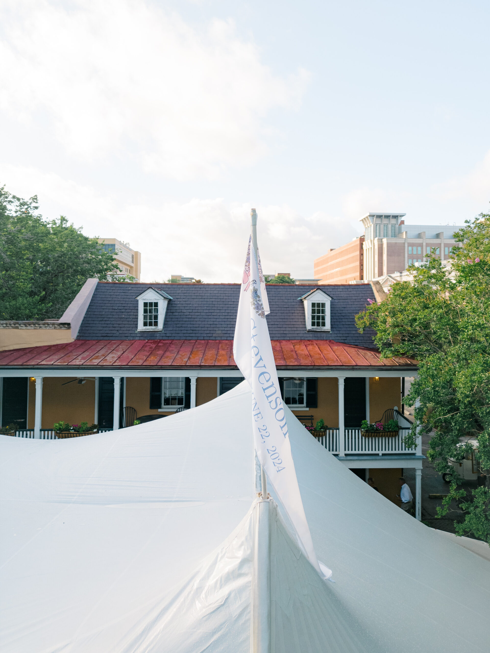 Custom flags on sailcloth tent. Outdoor wedding reception in downtown Charleston. 