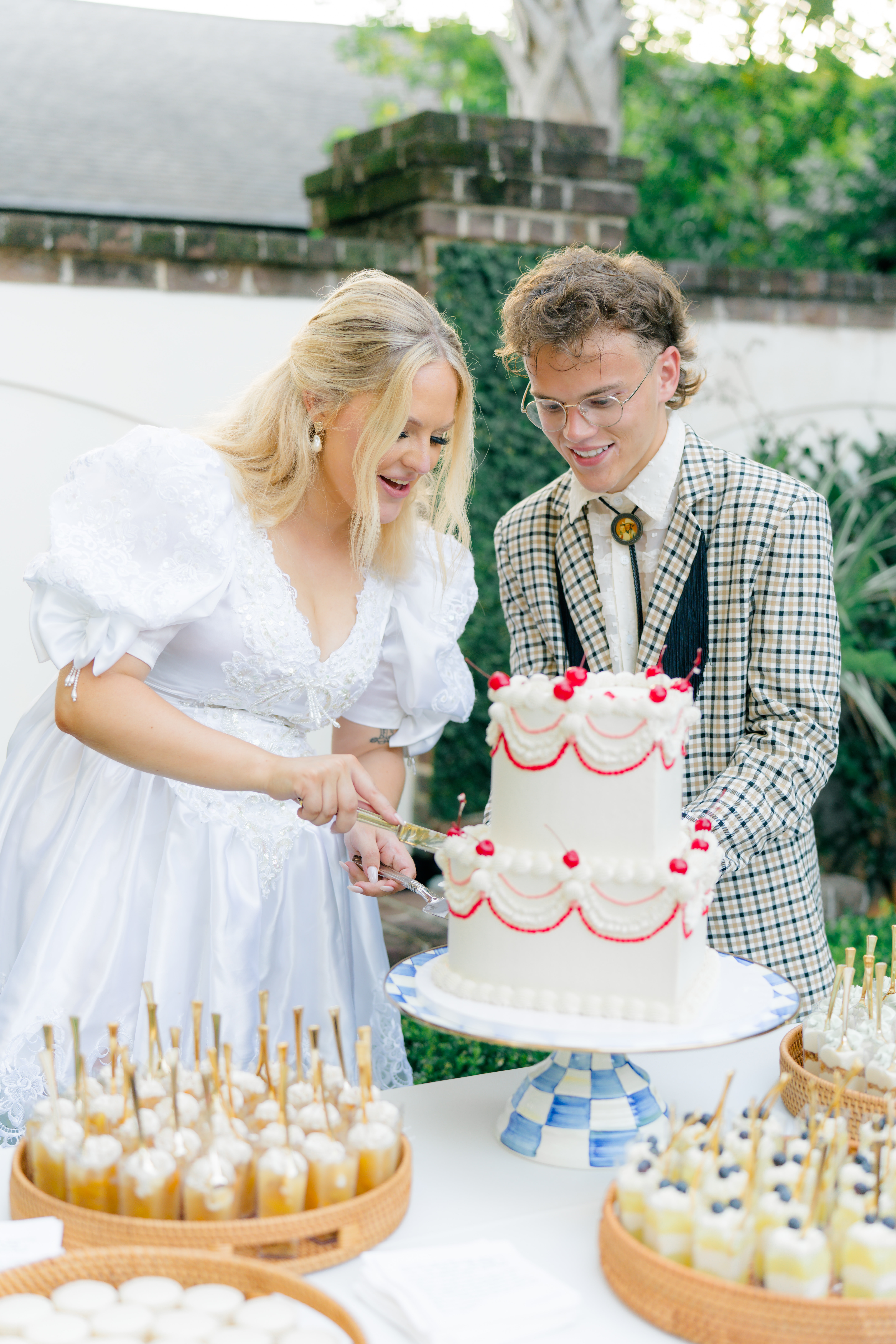 Bride and groom cut the cake. Both the bride and groom had epic second outfits at this Charleston spring wedding. 