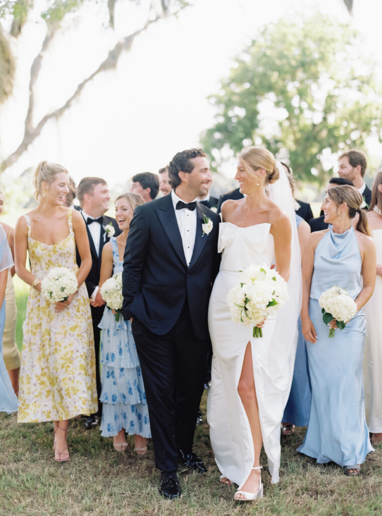 Bride and groom walking with bridal party. 