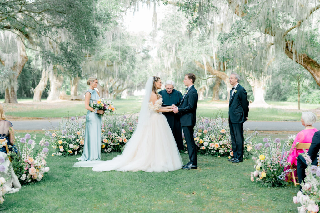 Spring outdoor wedding ceremony in the lowcountry. Bride and groom standing at wedding ceremony. 