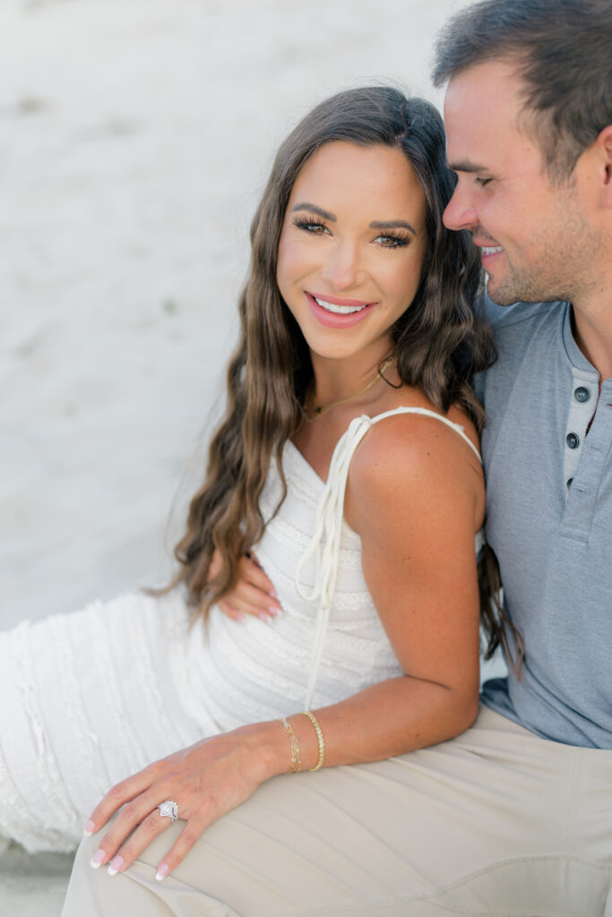 Charleston beach maternity photos. Couple sitting in the sand. 