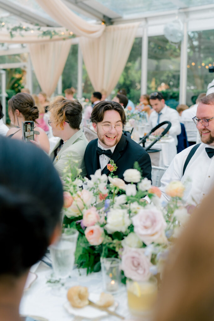 Candid wedding guest laughing. 