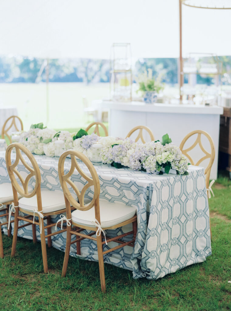 Blue and white patterned table linens with simple flowers. 